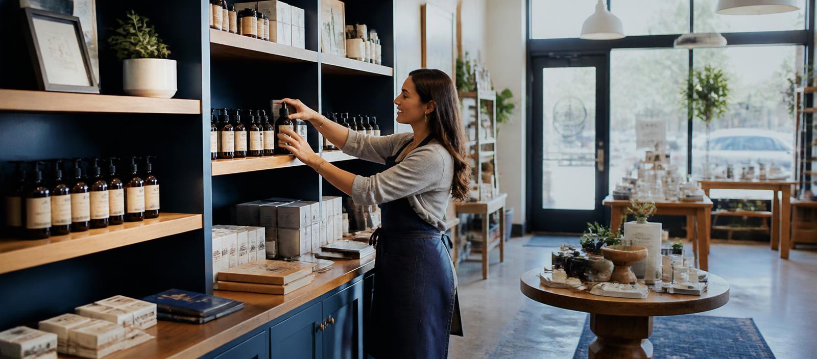 A retail shop owner stocking shelves in her thriving store